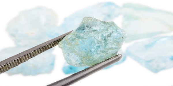 raw aquamarine stone examined